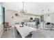 Open dining area with a large white table, tufted chairs, and views into the kitchen and breakfast bar at 12120 Sumter Dr, Orlando, FL 32824