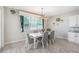 Light and bright dining room with large windows, white table and chairs, and a stylish light fixture at 12120 Sumter Dr, Orlando, FL 32824