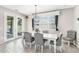 Dining room features a white table with tufted chairs, a modern light fixture, and double doors to the backyard at 12120 Sumter Dr, Orlando, FL 32824