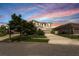 Charming two-story home with a well-manicured lawn and a spacious driveway at sunset at 12120 Sumter Dr, Orlando, FL 32824