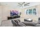 Cozy living room featuring a comfortable gray sofa, large television, and natural light from a window at 12120 Sumter Dr, Orlando, FL 32824