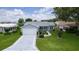 Aerial view of home with a long decorative driveway and manicured lawn at 1225 Zapata Pl, The Villages, FL 32159