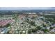 A broad aerial perspective of a community featuring a mix of houses, lush greenery, and a scenic lake at 1225 Zapata Pl, The Villages, FL 32159
