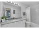 Bathroom with granite countertops, white cabinets, and bathtub and shower combo at 1225 Zapata Pl, The Villages, FL 32159