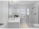 All-white bathroom featuring a glass walk-in shower, quartz counters, and natural light at 1225 Zapata Pl, The Villages, FL 32159
