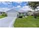 Charming single-story home with a well-manicured lawn, tidy landscaping, and a two-car garage at 1225 Zapata Pl, The Villages, FL 32159