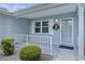Inviting front porch with a wreath on the door and a railing providing safety and appeal at 1225 Zapata Pl, The Villages, FL 32159