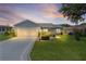 Exterior view of home showcasing driveway, front yard and manicured landscaping at 1225 Zapata Pl, The Villages, FL 32159
