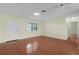 Spacious living room showcasing wood floors, a ceiling fan, and a door leading to another room at 1225 Zapata Pl, The Villages, FL 32159