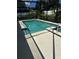 Screened-in pool with inviting blue water, surrounded by a spacious concrete patio and lush landscaping at 13109 Laurel Crest Ct, Grand Island, FL 32735