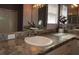 Bathroom vanity with a granite counter, decorative faux flower, and a framed mirror at 1412 Forest Acres Dr, The Villages, FL 32162