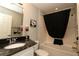 A bathroom with a black marble vanity, a combined bathtub and shower and white tiles at 1412 Forest Acres Dr, The Villages, FL 32162