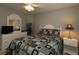 A bedroom with a queen size bed, ceiling fan, dresser and a plant at 1412 Forest Acres Dr, The Villages, FL 32162