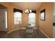 Cozy dining area features a glass table, chandelier, and sunny windows with decorative valances at 1412 Forest Acres Dr, The Villages, FL 32162