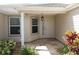 Covered front porch with decorative plants, stone tile flooring, and a stylish hanging lantern fixture at 1412 Forest Acres Dr, The Villages, FL 32162
