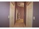 Hallway with a neutral carpet and paint, multiple doors, and a decorative standing mirror at 1412 Forest Acres Dr, The Villages, FL 32162