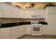 Updated kitchen featuring white cabinetry, granite countertops, and modern appliances, perfect for cooking and entertaining at 1412 Forest Acres Dr, The Villages, FL 32162
