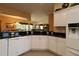Large kitchen with white cabinets, dark granite countertops, and a view to the dining room at 1412 Forest Acres Dr, The Villages, FL 32162