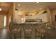 Open kitchen design featuring barstool seating, white cabinetry, and stainless steel appliances at 1412 Forest Acres Dr, The Villages, FL 32162