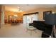 Open-concept living room and dining area with a large black sofa and glass table at 1412 Forest Acres Dr, The Villages, FL 32162