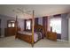 Elegant main bedroom featuring a four-poster bed, ceiling fan, and ample natural light at 1412 Forest Acres Dr, The Villages, FL 32162