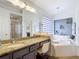 Bathroom featuring a vanity area, large mirror, soaker tub, and neutral color palette at 167 Castaway Beach Way, Kissimmee, FL 34746