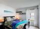 Cozy bedroom featuring tropical themed bedding, decorative shelves, and bright window at 167 Castaway Beach Way, Kissimmee, FL 34746
