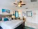 Sunlit bedroom with a view to an outdoor area and has a ceiling fan and coastal themed decor at 167 Castaway Beach Way, Kissimmee, FL 34746