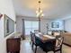 Open-concept dining room with a modern chandelier and stylish furniture at 167 Castaway Beach Way, Kissimmee, FL 34746