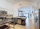 Open-concept kitchen showcasing stainless steel appliances, and seamless flow into living area at 167 Castaway Beach Way, Kissimmee, FL 34746