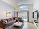 Bright living room featuring a comfortable sectional sofa, modern lighting, and view of the pool at 167 Castaway Beach Way, Kissimmee, FL 34746
