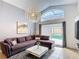 Stylish living room with large windows, comfortable sectional sofa, and access to the outdoor pool area at 167 Castaway Beach Way, Kissimmee, FL 34746