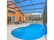 Screened in pool with an orange home, patio furniture, and outdoor access at 167 Castaway Beach Way, Kissimmee, FL 34746
