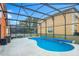 Screened in pool with patio and an orange home's backyard at 167 Castaway Beach Way, Kissimmee, FL 34746
