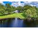 Scenic aerial shot of home on lakefront property featuring a private dock surrounded by lush trees at 168 Pond Rd, Mount Dora, FL 32757