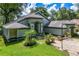 Charming one-story home with lush landscaping, covered front porch, and a paved walkway at 168 Pond Rd, Mount Dora, FL 32757