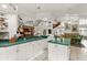 Bright kitchen with island, white cabinetry, eat-in table, and green countertops at 168 Pond Rd, Mount Dora, FL 32757