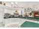 View of kitchen with white cabinets, green counters, stainless appliances and tile floors at 168 Pond Rd, Mount Dora, FL 32757