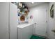 Cozy laundry room featuring a washer, dryer, shelving, and a green floor mat at 168 Pond Rd, Mount Dora, FL 32757