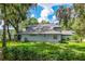 Expansive backyard with lush landscaping, mature trees, and partial views of the lake at 168 Pond Rd, Mount Dora, FL 32757