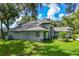 Spacious backyard featuring lush greenery and views of the serene lake beyond at 168 Pond Rd, Mount Dora, FL 32757