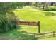 A welcoming 'Sunset Pond' sign is set against a backdrop of a beautiful lawn at 168 Pond Rd, Mount Dora, FL 32757