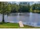 Scenic view of the tranquil lake with a wooden dock, surrounded by lush greenery and trees at 168 Pond Rd, Mount Dora, FL 32757