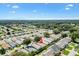 A high up aerial view of homes in a quiet neighborhood, tree-lined streets and well-maintained landscaping at 16938 Se 94Th Sunnybrook Cir, The Villages, FL 32162