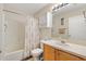 The bathroom includes a vanity with storage, toilet, and shower with patterned shower curtain at 16938 Se 94Th Sunnybrook Cir, The Villages, FL 32162