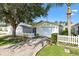 Home featuring a white picket fence, attached garage, and well-maintained landscaping at 16938 Se 94Th Sunnybrook Cir, The Villages, FL 32162