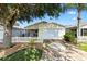 Charming home featuring a white picket fence, mature trees, and attached garage at 16938 Se 94Th Sunnybrook Cir, The Villages, FL 32162