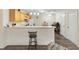 Eat-in kitchen with breakfast bar, white appliances, and neutral countertops at 16938 Se 94Th Sunnybrook Cir, The Villages, FL 32162