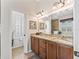 Bathroom with granite counters, decorative light fixtures, with toilet room behind louvered door at 17599 Se 121St Cir, Summerfield, FL 34491