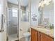 Bathroom with glassed-in shower and vanity with granite counters and bronze fixtures at 17599 Se 121St Cir, Summerfield, FL 34491